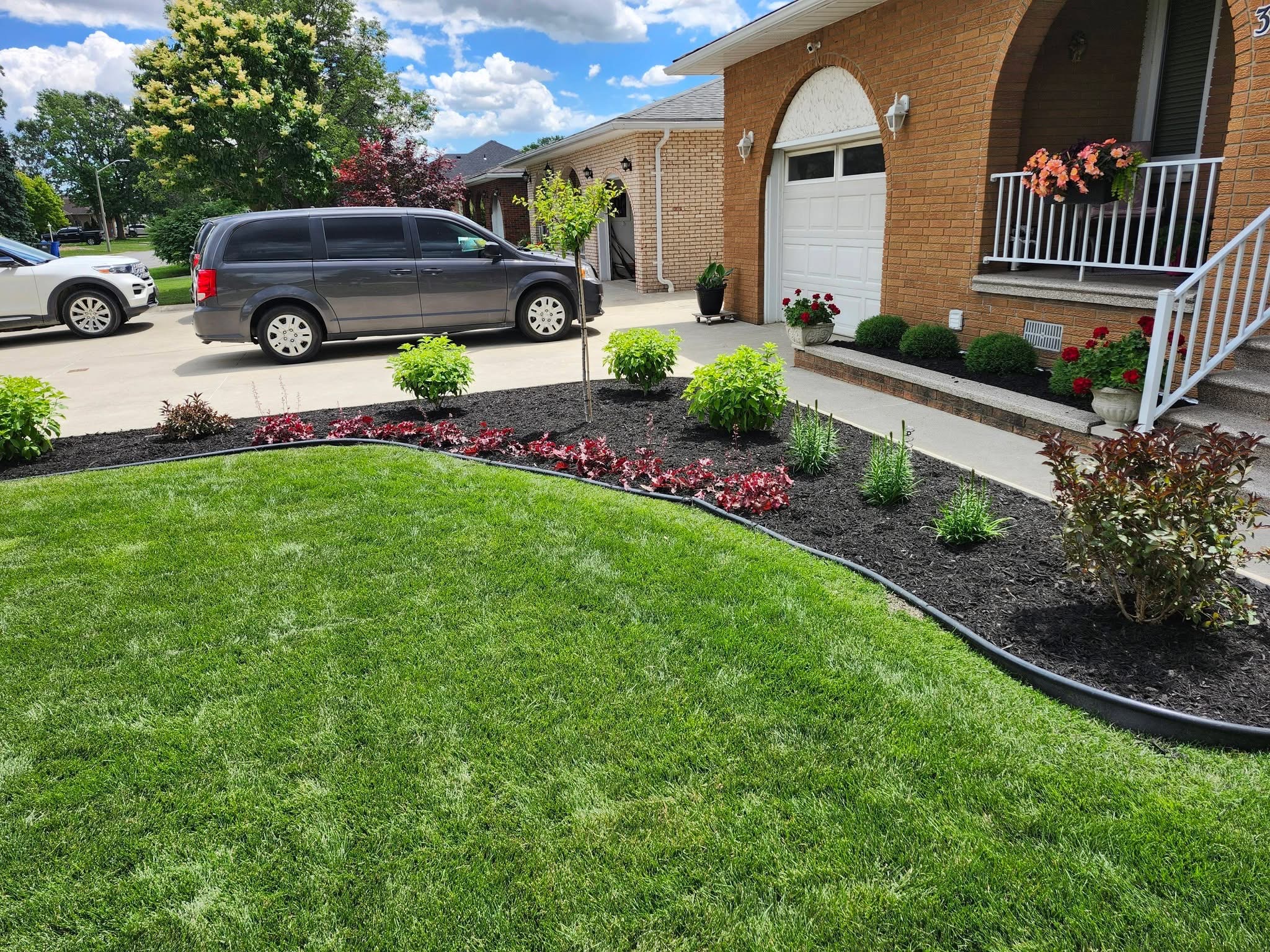 Freshly landscaped front yard with curved garden beds and new plantings